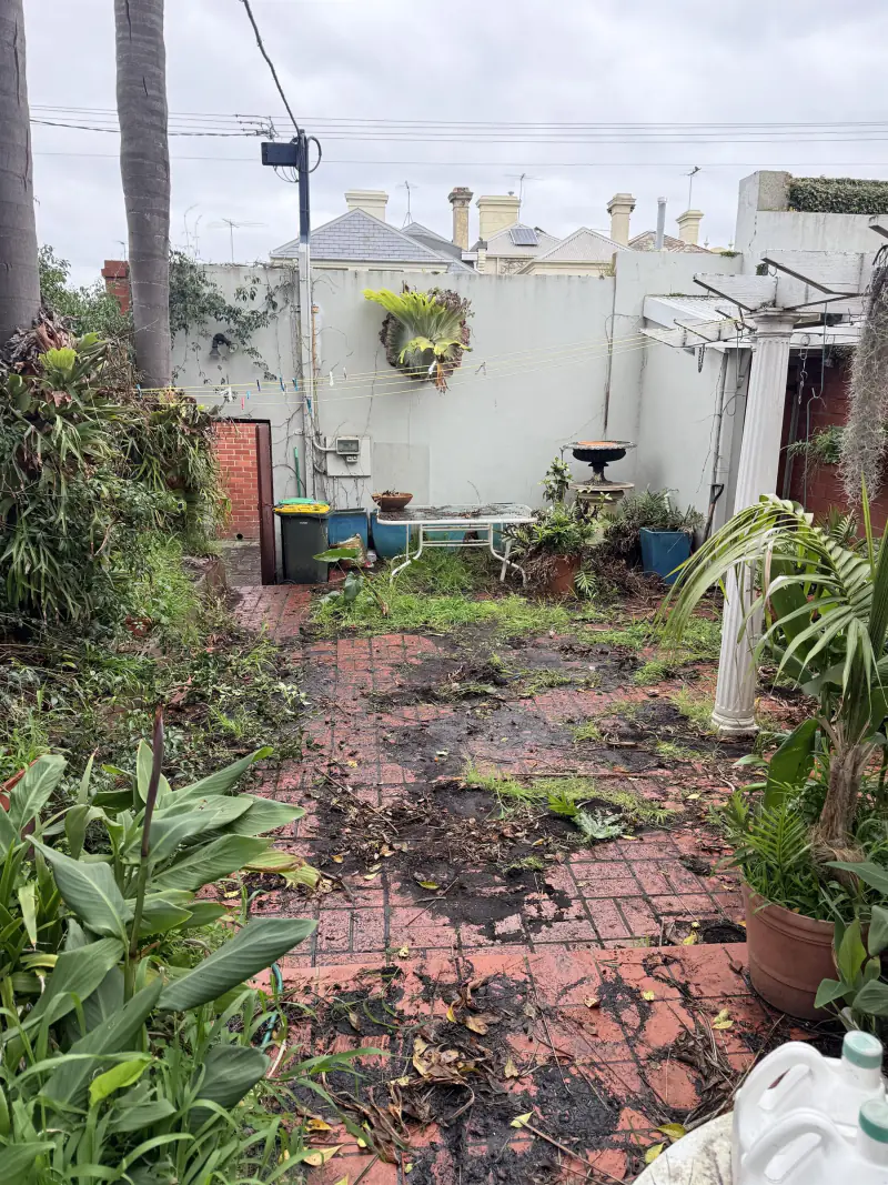 The same courtyard with the pots and green waste removed and the brick paving visible again
