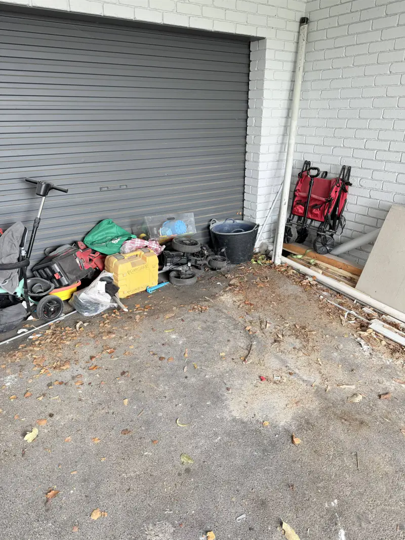 The same garage entrance cleared and swept, with only the items the owner was keeping left in place